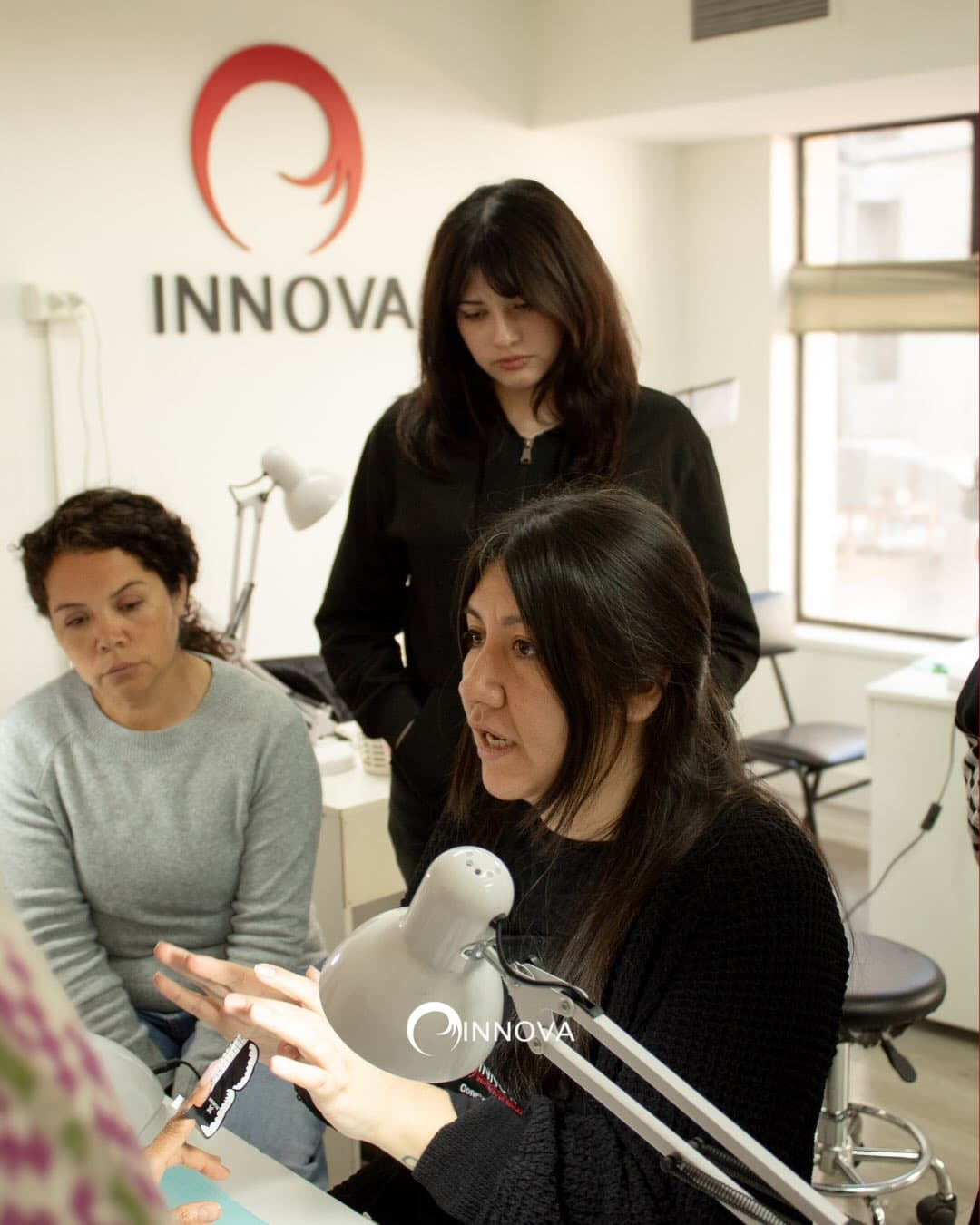 Instructora explicando una técnica a dos alumnas durante una clase en Instituto Innova